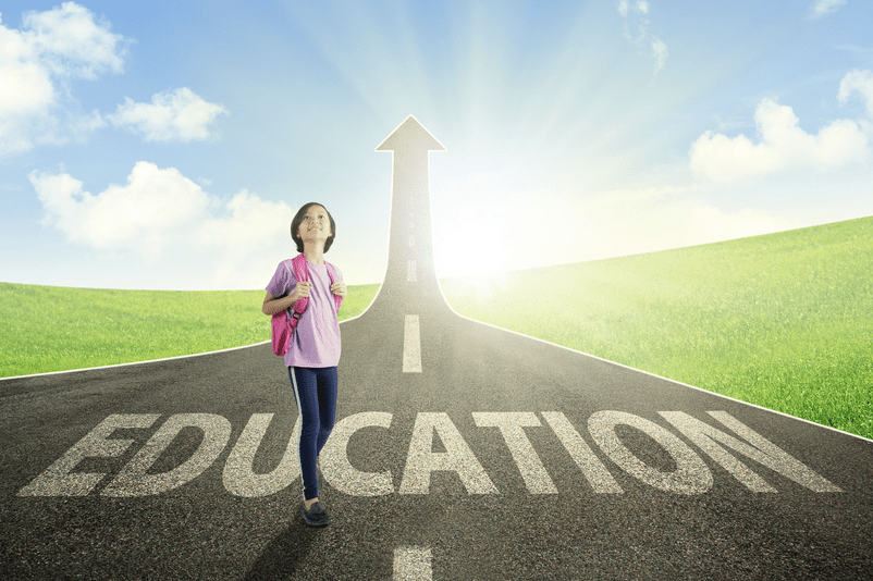 Image of a little girl in front of a road leading up with the word "Education."
