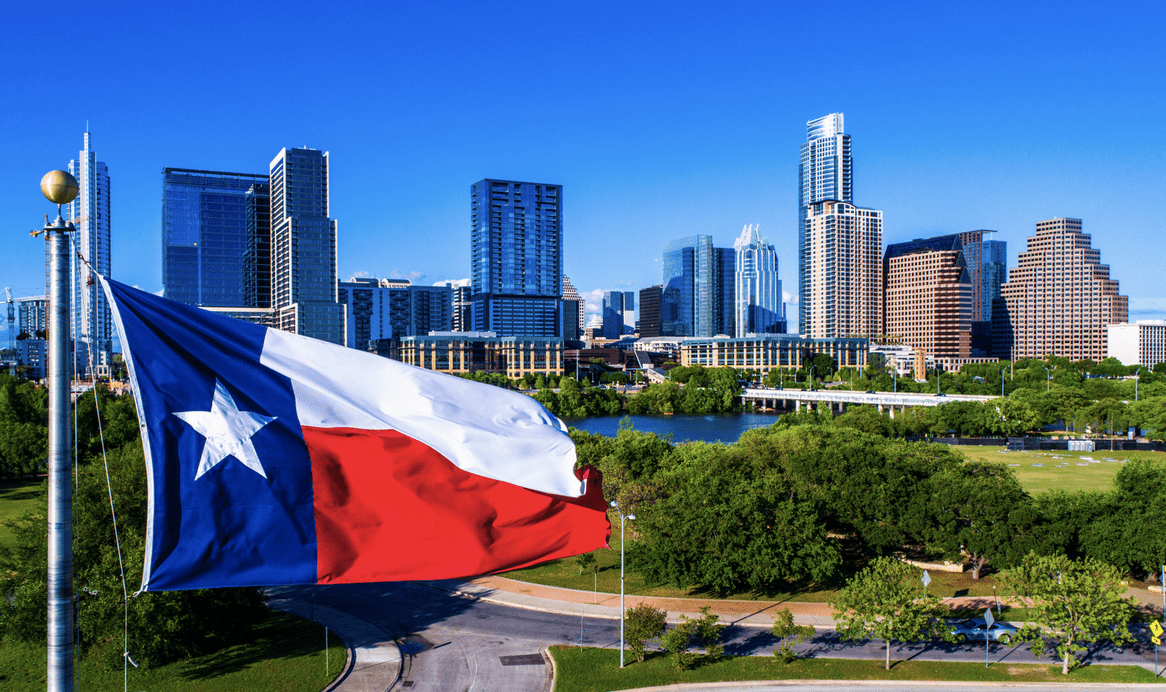 Image of Texas flag and a city in the state behind it.